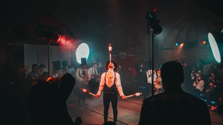 A mesmerizing circus juggler performs under dramatic lighting during a lively festival.